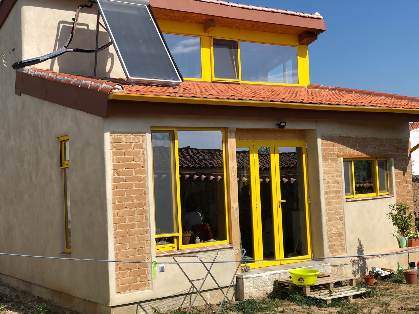 Fachada de la Casa de Paja en Peraleda de la Mata, con termosolar en cubierta